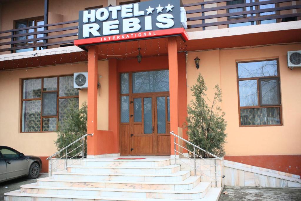 un hotel con un cartel en la parte delantera de un edificio en Hotel Rebis, en Brăila
