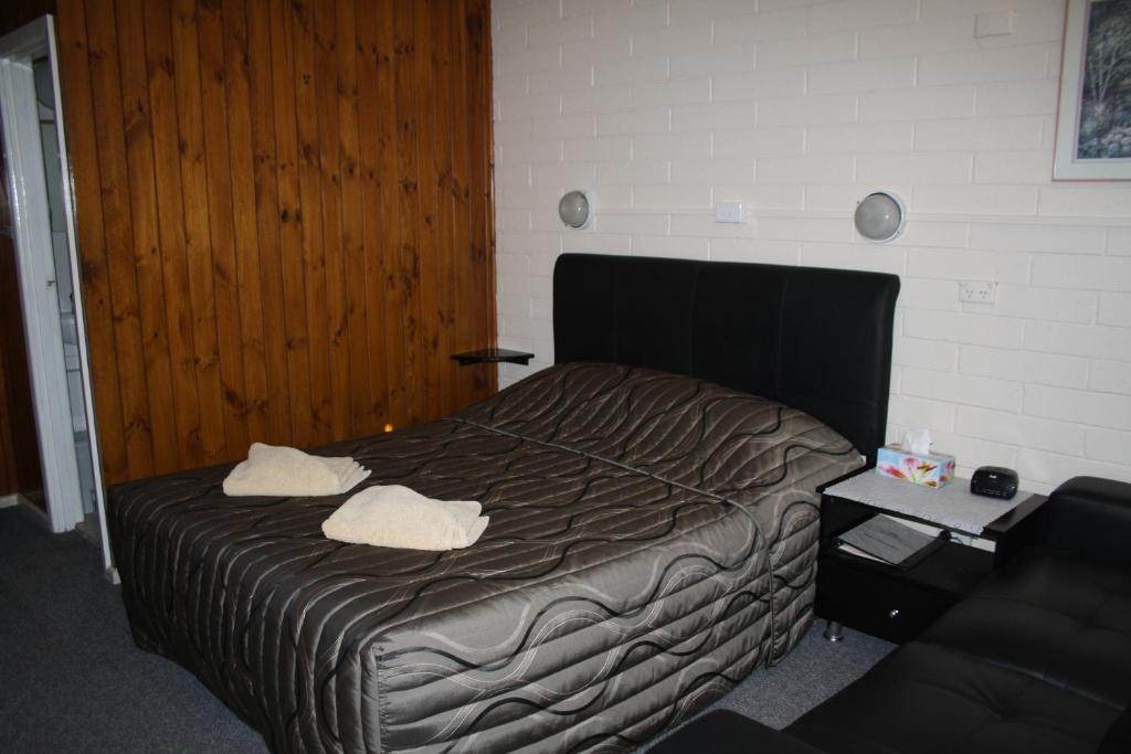 1 dormitorio con 1 cama con 2 toallas en Nhill Oasis Motel, en Nhill