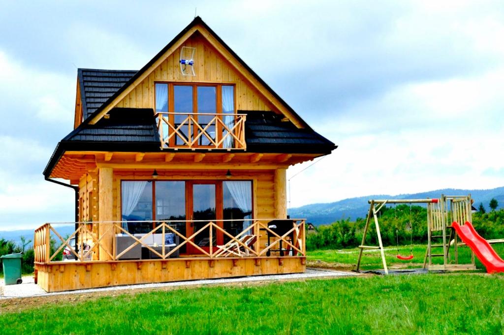 a tiny house with a playground and a slide at Domek Pod Limbami II in Kluszkowce