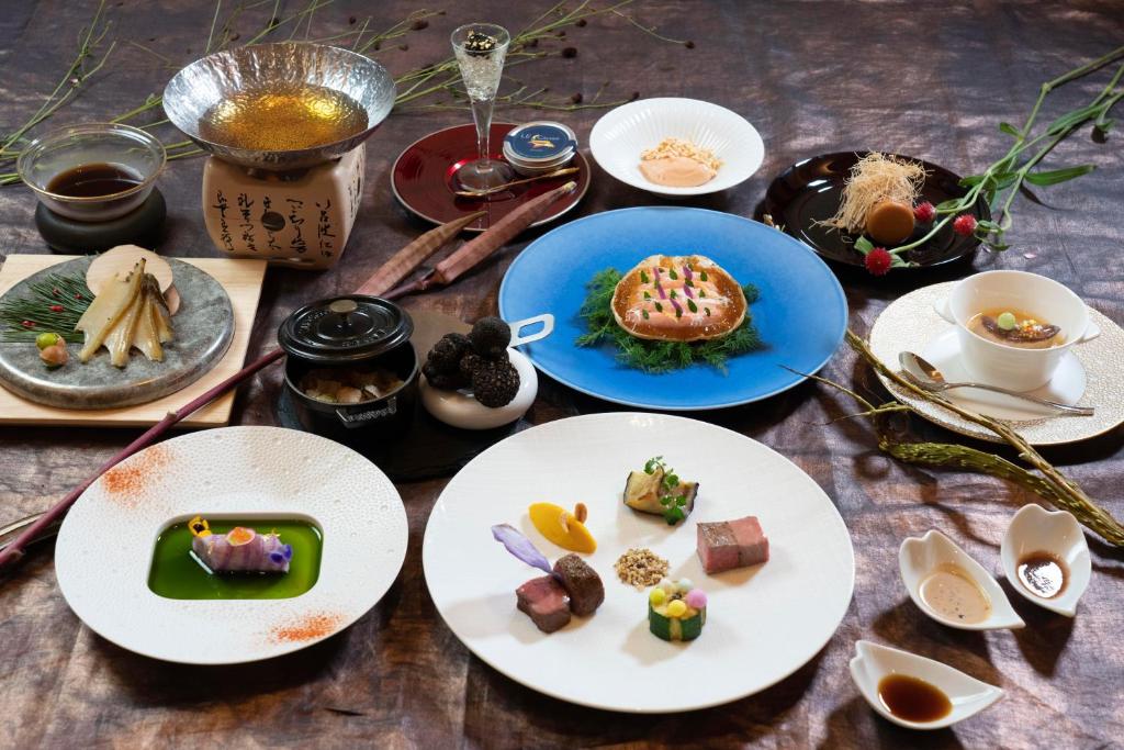 una mesa con platos de comida. en Hotel Riverge Akebono, en Fukui