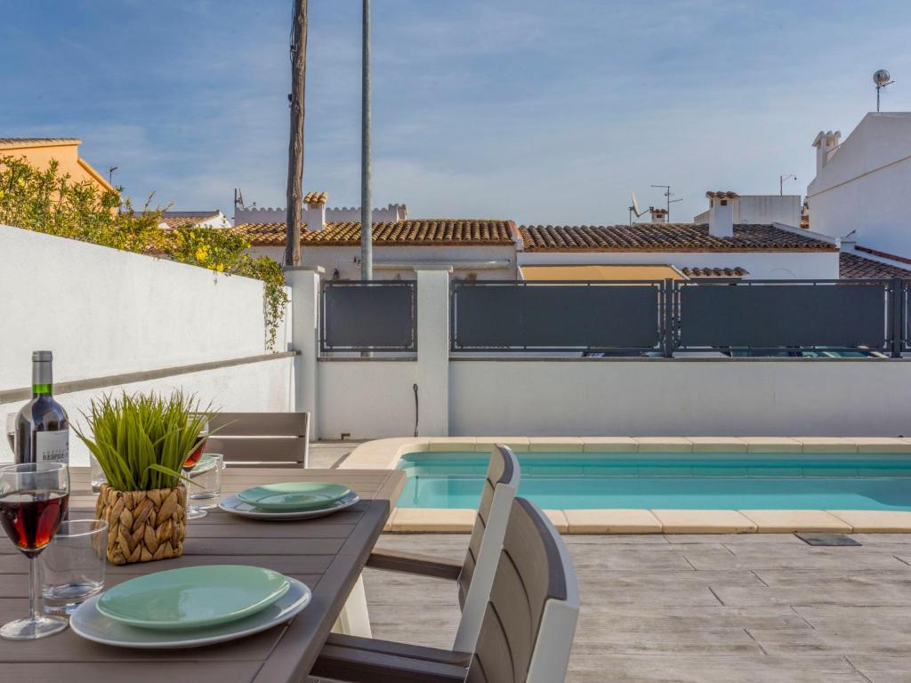 een terras met een tafel en een zwembad bij Holiday Home Sangha by Interhome in Empuriabrava