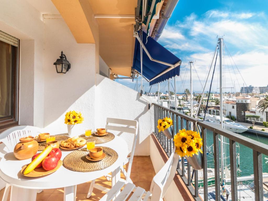 d'un balcon avec une table et de la nourriture et une vue sur le port. dans l'établissement Apartment Caballito de Mar by Interhome, à Empuriabrava