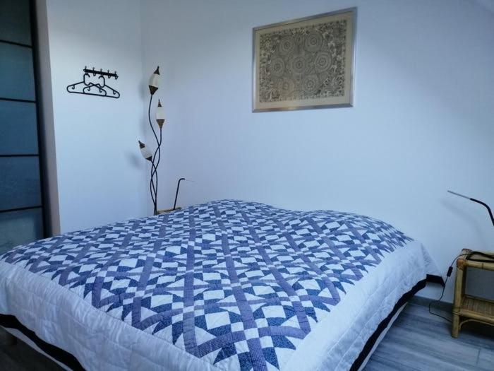 a bedroom with a blue and white bed in a room at La Grange à outeaux in Montpont-en-Bresse