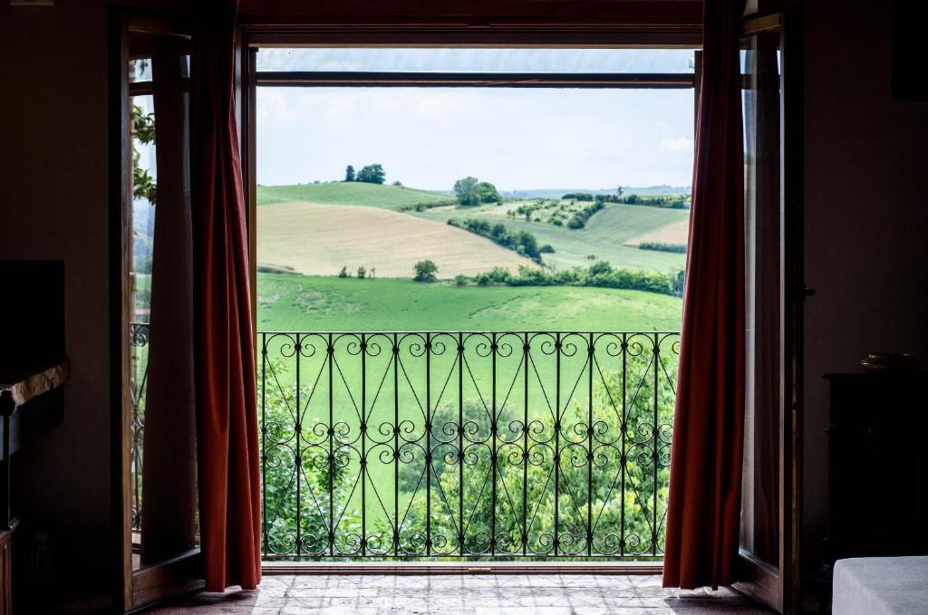 a room with a view of a green field from a window at Tenuta San Rocco in Conzano