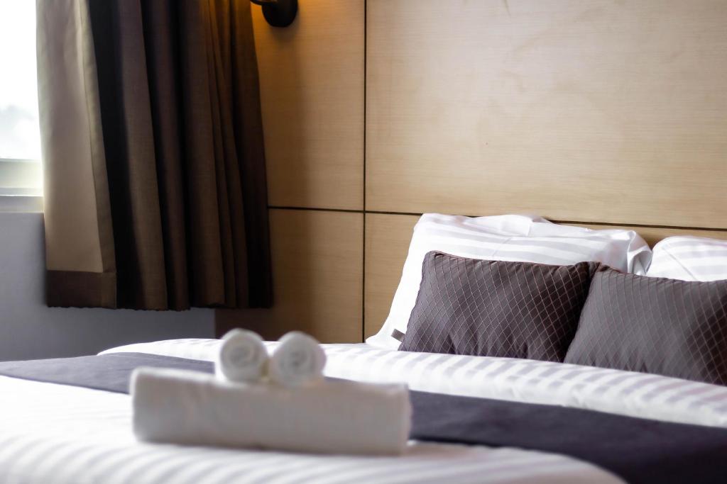 a hotel room with a bed with towels on it at Montree Phuket Hotel in Phuket Town