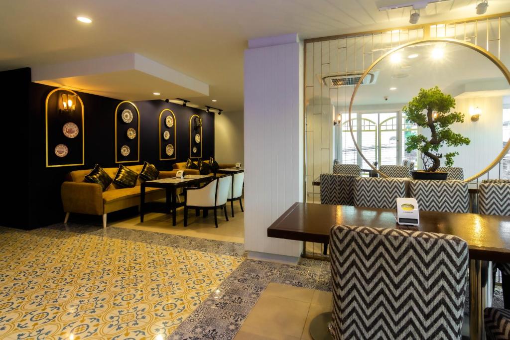 a dining room with a table and chairs at Montree Phuket Hotel in Phuket Town