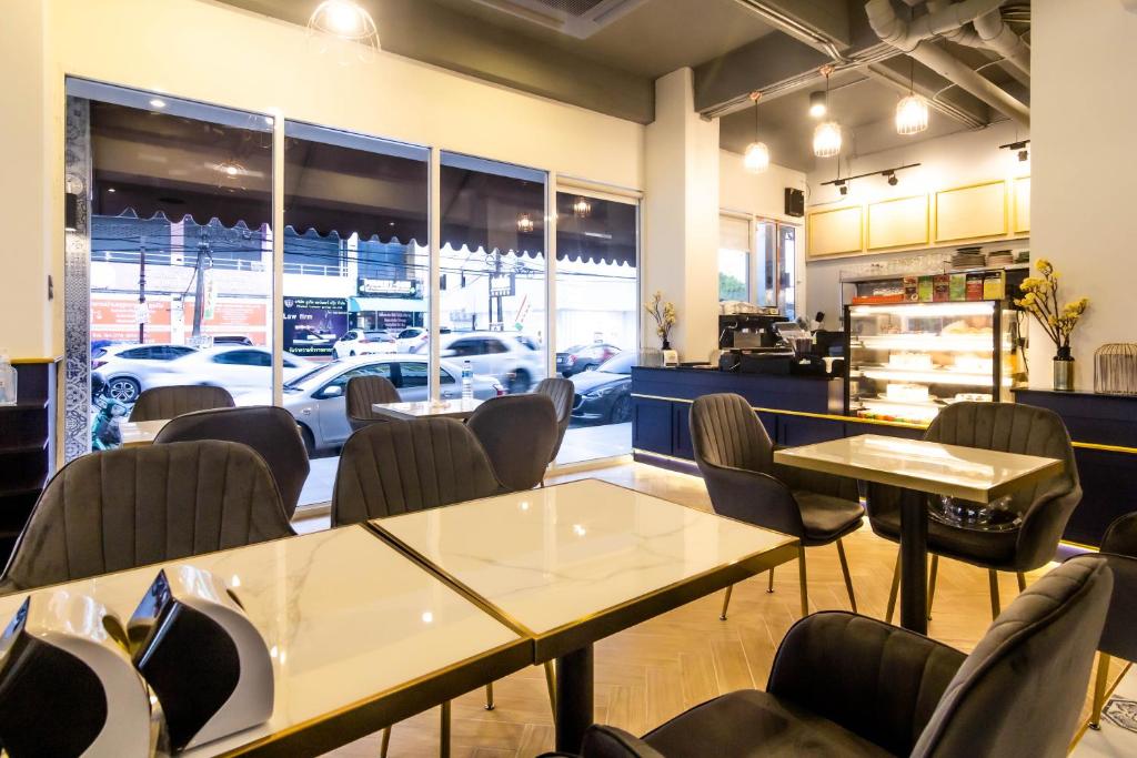 a restaurant with tables and chairs and a car dealership at Montree Phuket Hotel in Phuket Town