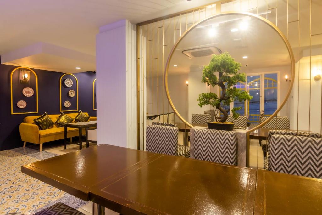 a table and chairs in a room with a mirror at Montree Phuket Hotel in Phuket Town