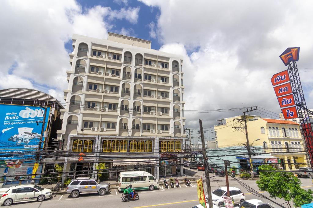 a tall white building on a busy city street at Montree Phuket Hotel in Phuket Town