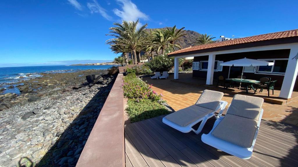 a house with a deck with chairs and a table at Casa Blanca - Sunset Villa in Valle Gran Rey