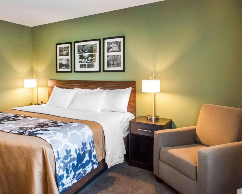 a hotel room with a bed and a chair at Sleep Inn & Suites Defuniak Springs - Crestview in Mossy Head