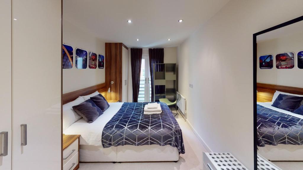 1 dormitorio con cama y espejo en Central Perks Apartment (sleeps 4) en Hull