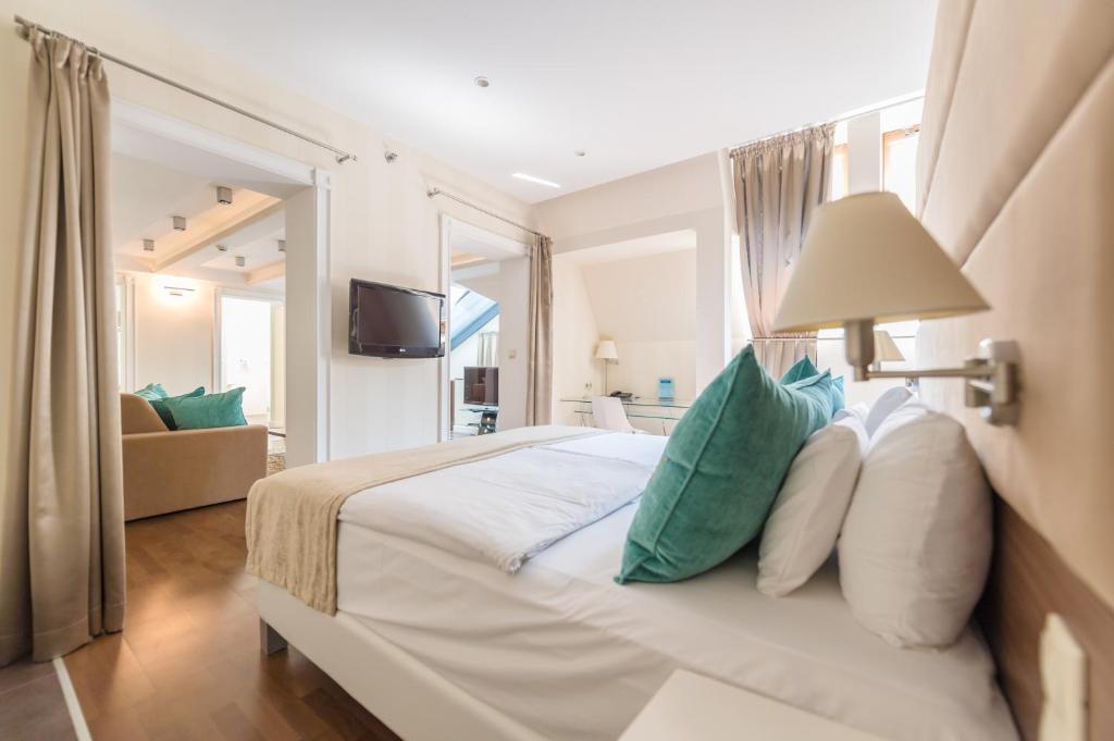 A bed or beds in a room at La Prima Fashion Hotel Budapest