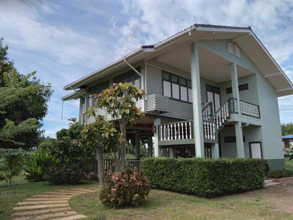 a house with a balcony and a tree at Green Home by Canal in Ban Tha Long Hip