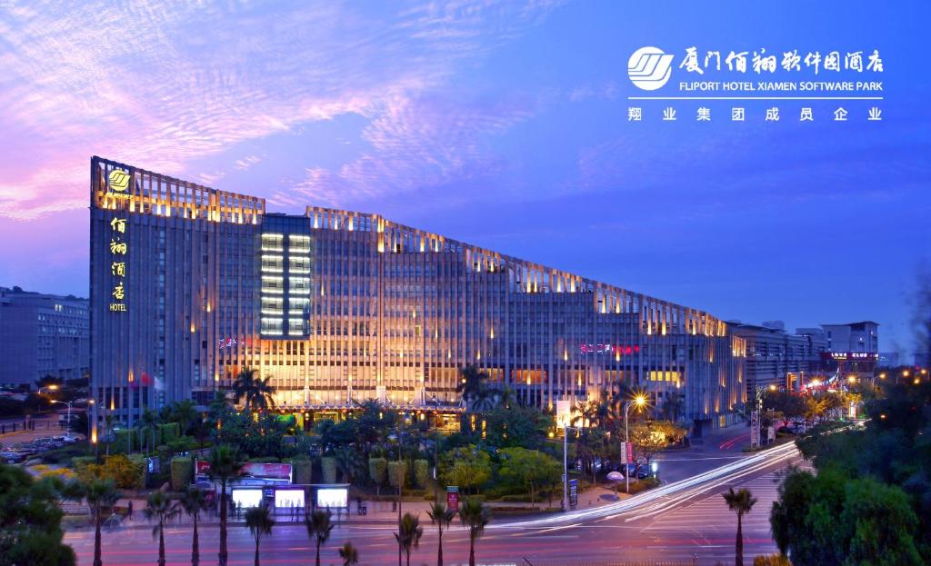 a large building with lights on it at night at FLIPORT Hotel Xiamen Software Park in Xiamen