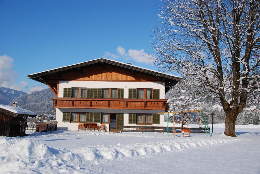 Una casa en la nieve con en Ferienhaus Resi & Obermoser, en Kössen