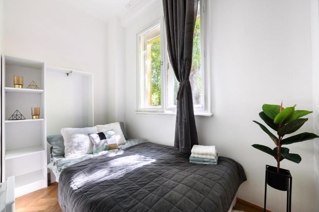 1 dormitorio con cama y ventana en Buda Centre Homes by the Allee Shopping Mall, en Budapest