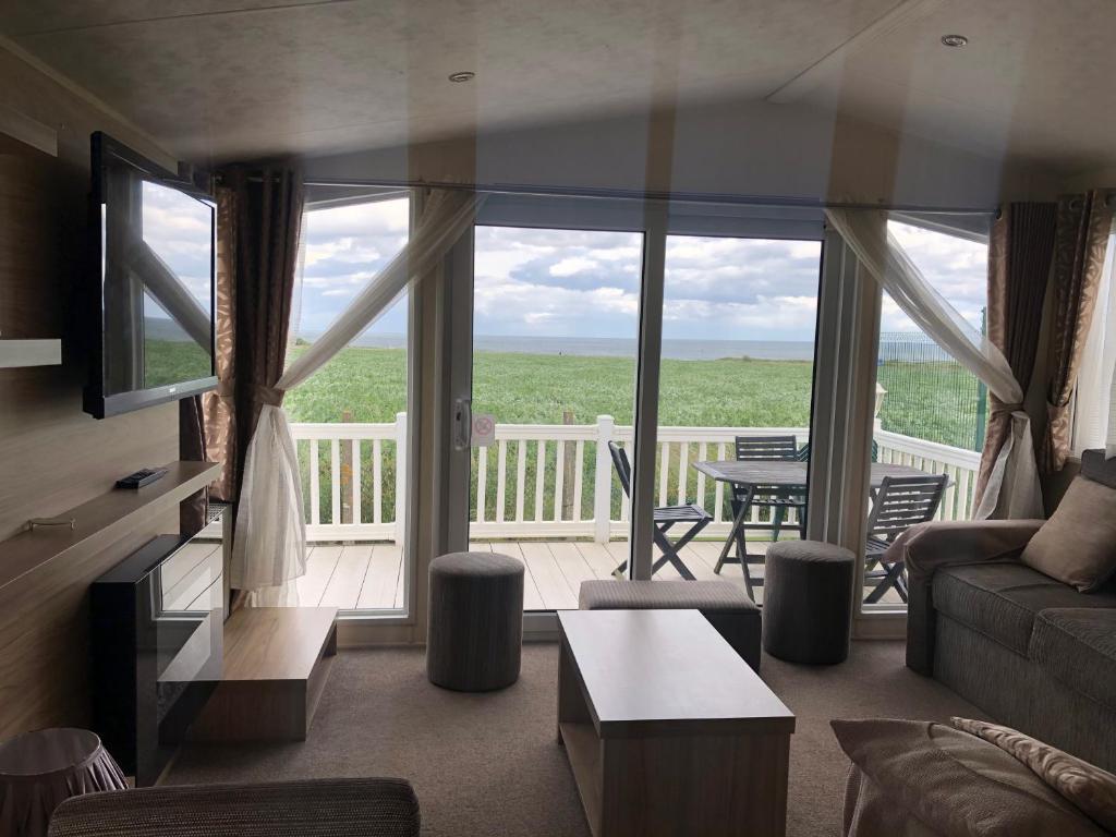 a living room with a view of a deck at Emmanuel Holiday Home in Whitley Bay