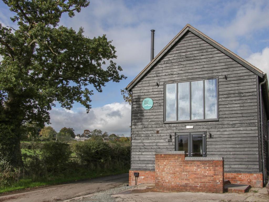 una piccola casa con una finestra sul lato di Black Lion Barn Retreat a Shrewsbury