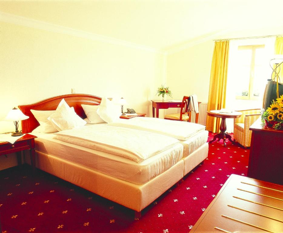a hotel room with a bed and a red carpet at Villa Hochdörffer Gästehaus in Landau in der Pfalz