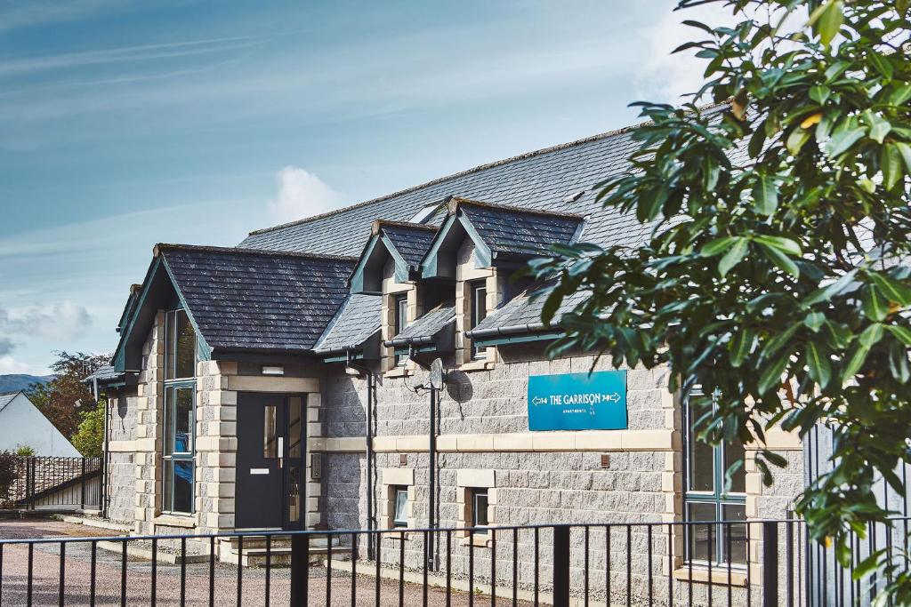 un bâtiment avec un panneau bleu devant lui dans l'établissement Garrison Apartments, à Fort William