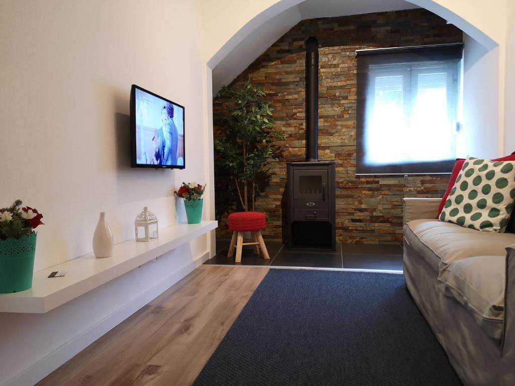 uma sala de estar com um sofá e uma parede de tijolos em ElevenPlace by LouzanPlaces em Lousã
