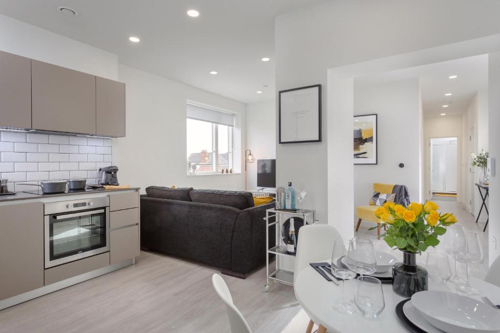 a kitchen and living room with a couch and a table at Luxury Serviced Apartments Stevenage, Hertfordshire in Stevenage