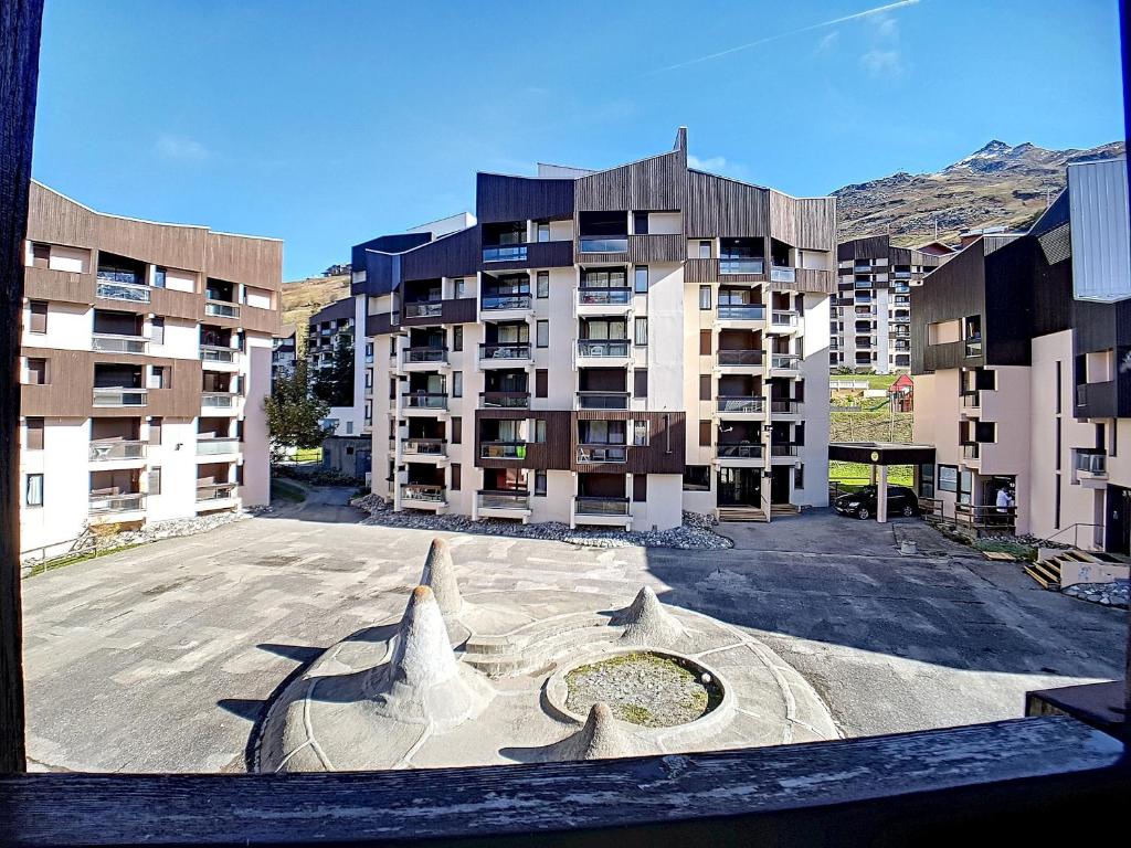 un parking vide devant un immeuble dans l'établissement travelski home classic - Résidence Origanes, aux Menuires