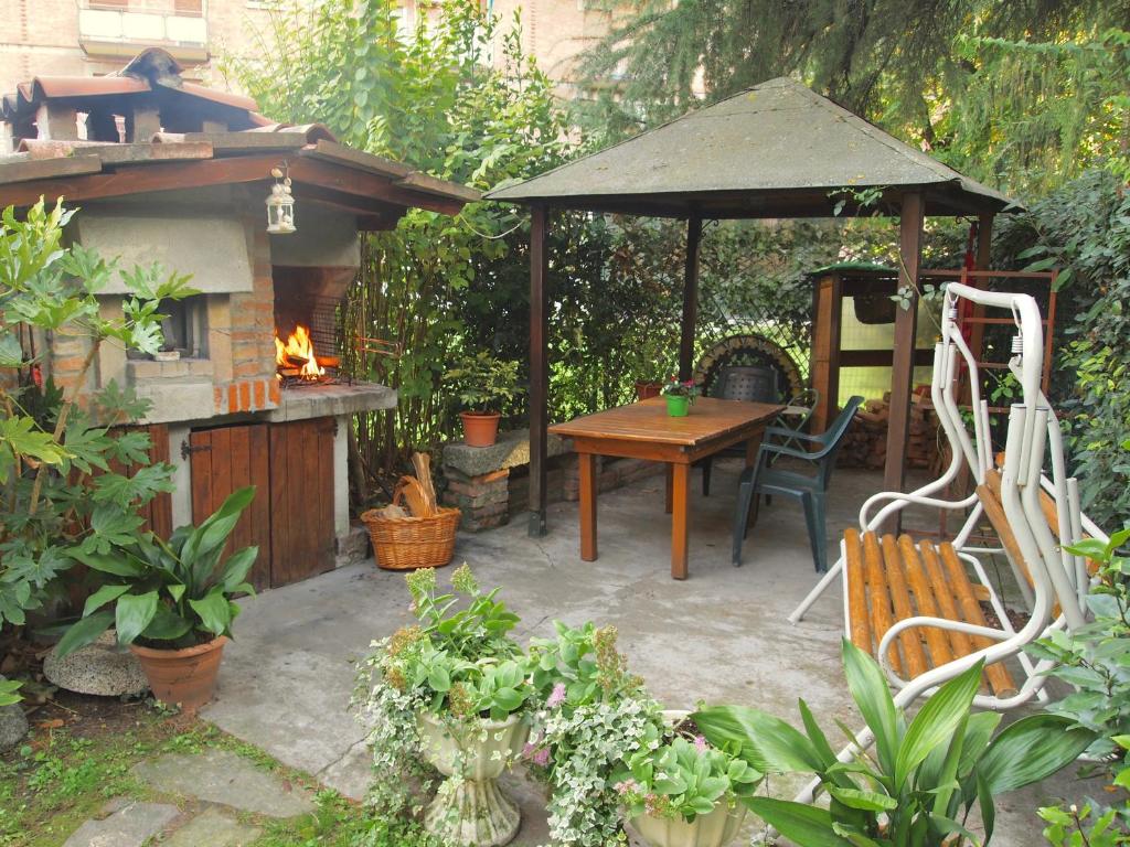 un jardín con mesa, cenador, mesa y sillas en B&B Casa Santina en Bolonia