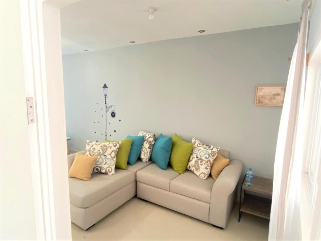 uma sala de estar com um sofá com almofadas coloridas em Casa nueva recien equipada y completa. em Chihuahua