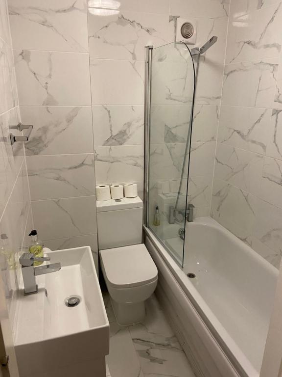 Abbey Lodge Hotel في لندن: حمام مع مرحاض وحوض استحمام ومغسلة