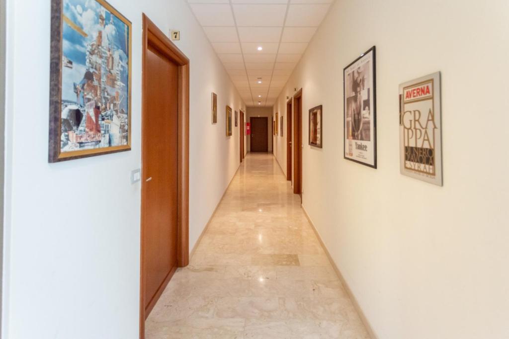 einen Korridor in einem Krankenhaus mit Gemälden an den Wänden in der Unterkunft Il Viandante Catenanuova in Catenanuova