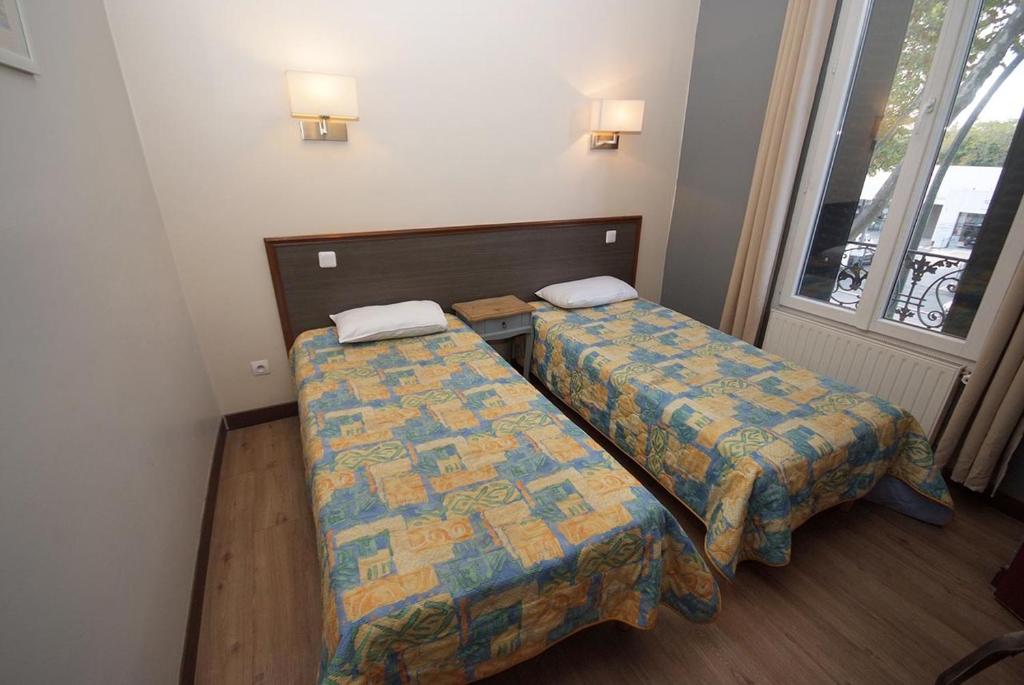 ein kleines Zimmer mit 2 Betten und einem Fenster in der Unterkunft Hôtel Le Bellevue - Paris Porte d'Orléans in Cachan