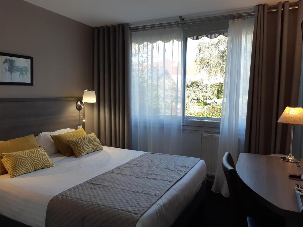 a hotel room with a bed and a window at Aerotel Versailles Saint Cyr - L'étape du Silence in Saint-Cyr-lʼÉcole