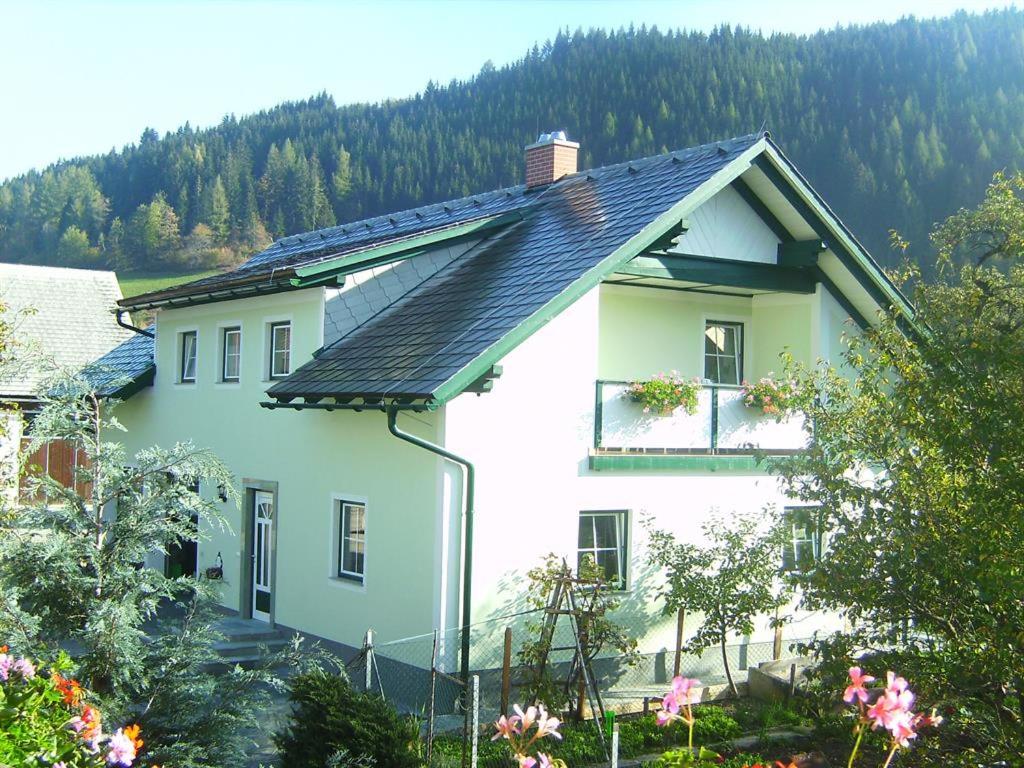 une maison blanche avec un toit noir dans l'établissement Bio-Ferienhof Hochbrandt, à Spital am Pyhrn