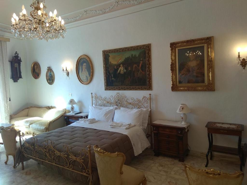 a bedroom with a bed and a chandelier at PEDRA HOUSE in Catania