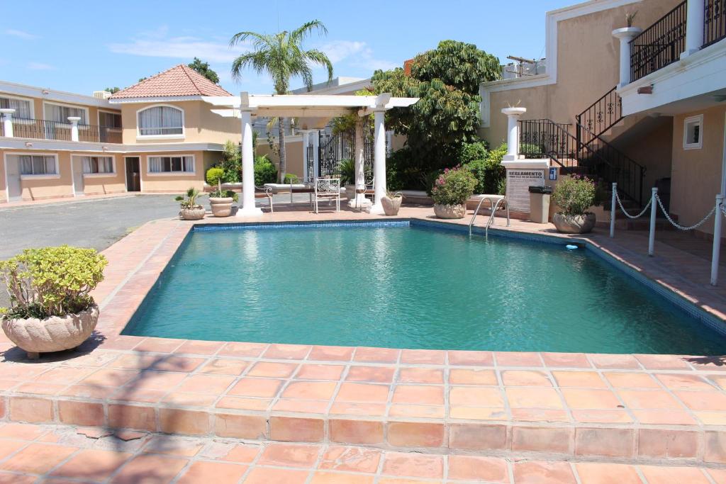 a swimming pool in front of a house at Hotel La Villa in Torreón