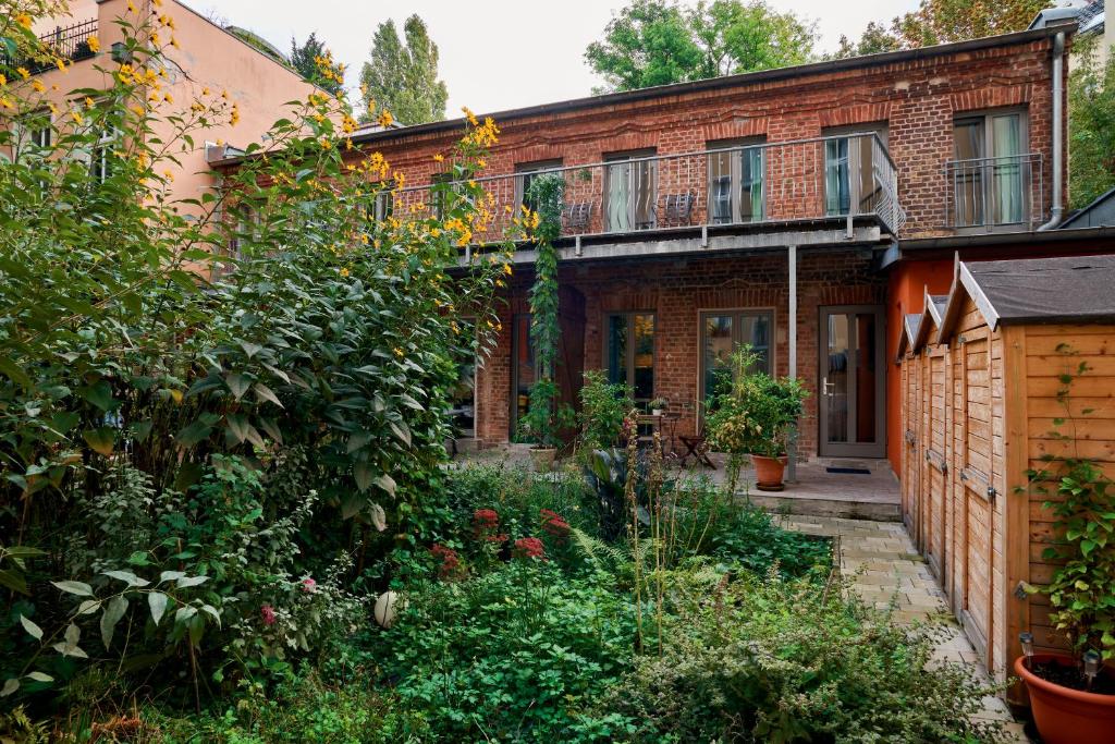an old brick house with a garden in front of it at Beautiful Backyard Remise in Berlin