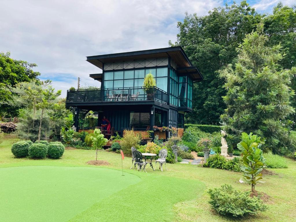 ein Haus mit Blick auf einen grünen Hof in der Unterkunft Baan Suanfah Kiangdao in Nan