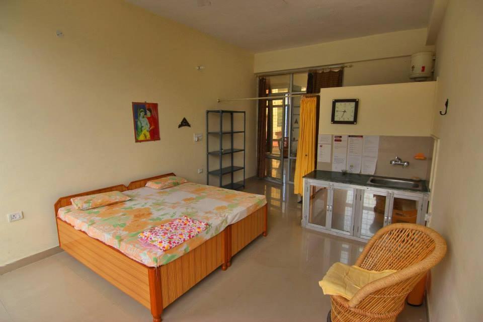 a bedroom with a large bed and a kitchen at Devi music ashram in Rishīkesh