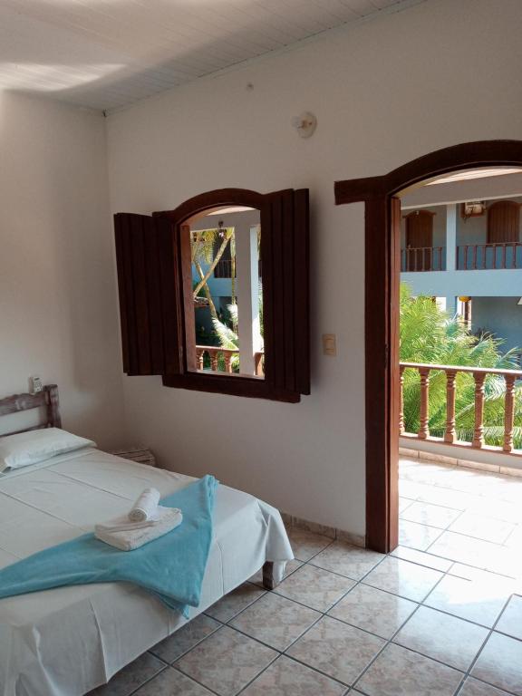 1 dormitorio con cama y ventana en Pousada Olhar da Sereia, en Arraial d'Ajuda