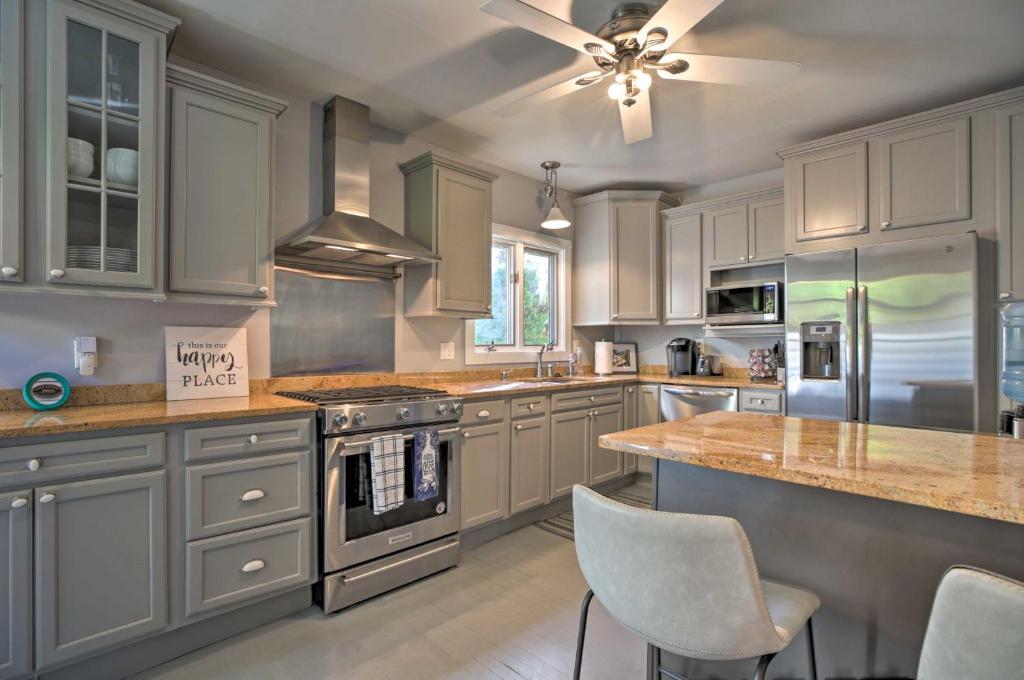 a kitchen with white cabinets and a ceiling fan at Dtwn Lake Geneva Home, Walk to Beach and Restaurants in Lake Geneva