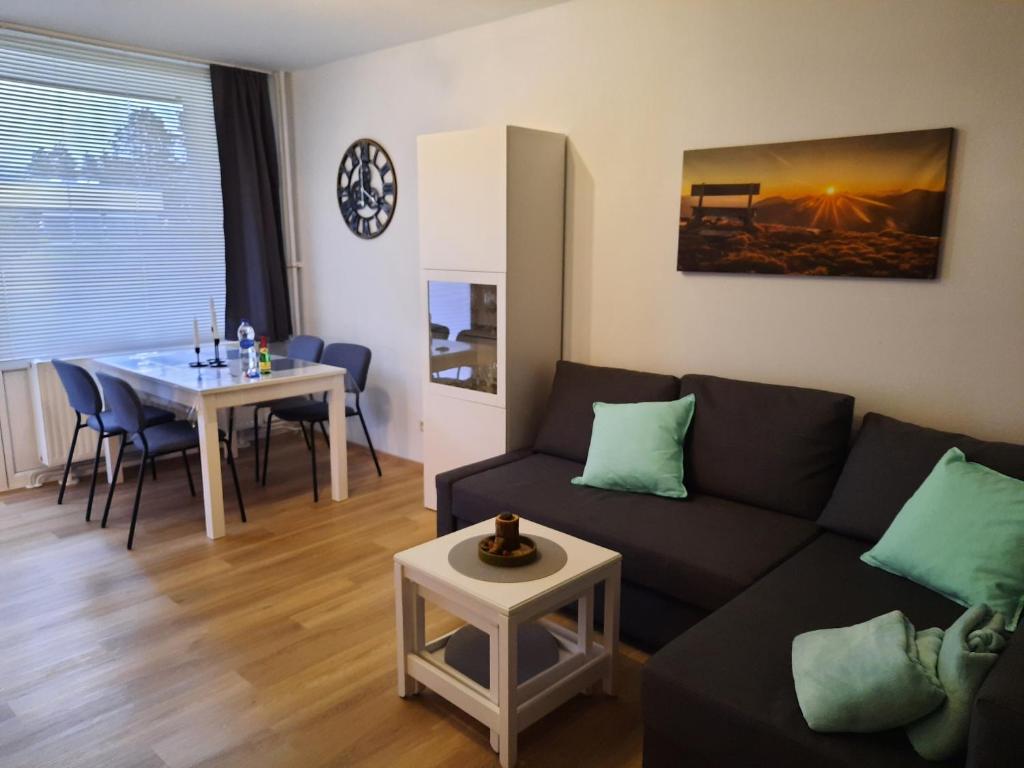 uma sala de estar com um sofá e uma mesa em Ferienwohnung Schneeweißchen an der Therme em Altenau