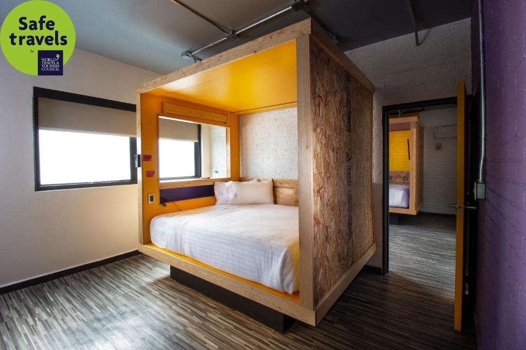 um quarto com uma cama com uma estrutura em madeira em Hotel MX roma em Cidade do México