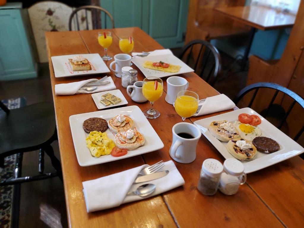 een houten tafel met borden ontbijtproducten erop bij Cleveland House Inn in Newport