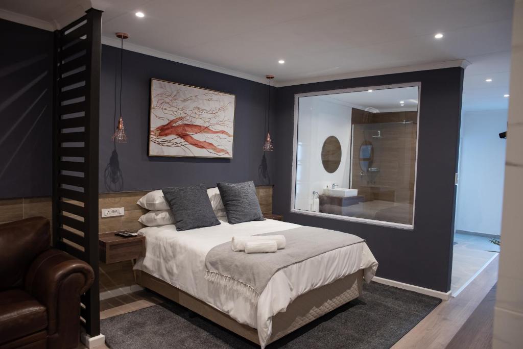 una camera con un grande letto e uno specchio di The Royal Bryanston a Johannesburg