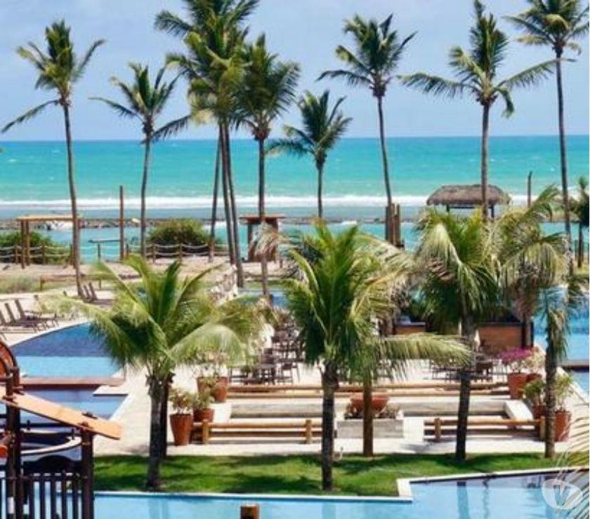 a view of a resort with palm trees and the beach at La Fleur Polinésia in Porto De Galinhas