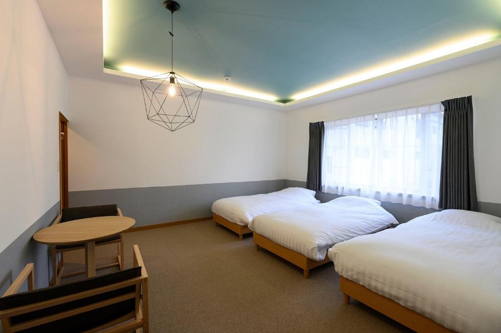 a room with two beds and a table and a window at BEYOND HOTEL Takayama 4th - Vacation STAY 99852 in Takayama