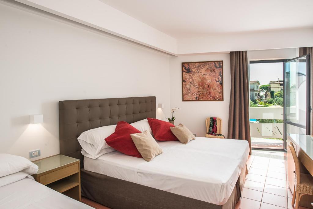 a bedroom with two beds and a large window at Rada Siri in Montepaone