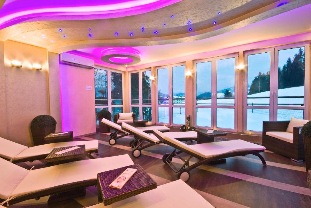 a salon with tables and chairs in a room with windows at Centrum Green Hill Business & SPA in Wisła